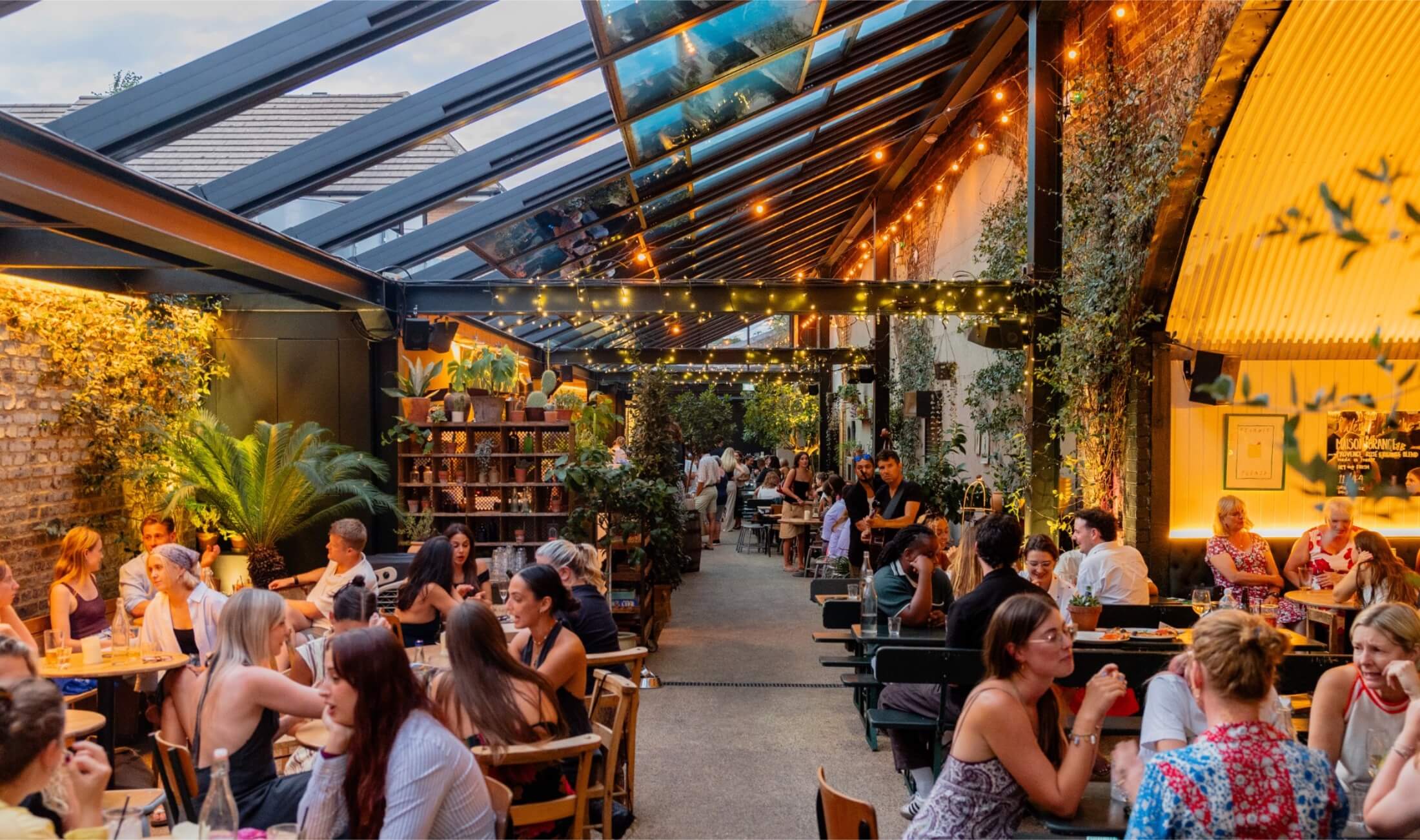Venue shot with people drinking and open roof