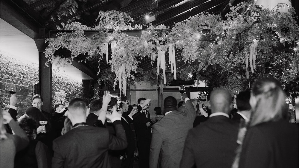 Guests cheering at a wedding party at The Hawk's Nest
