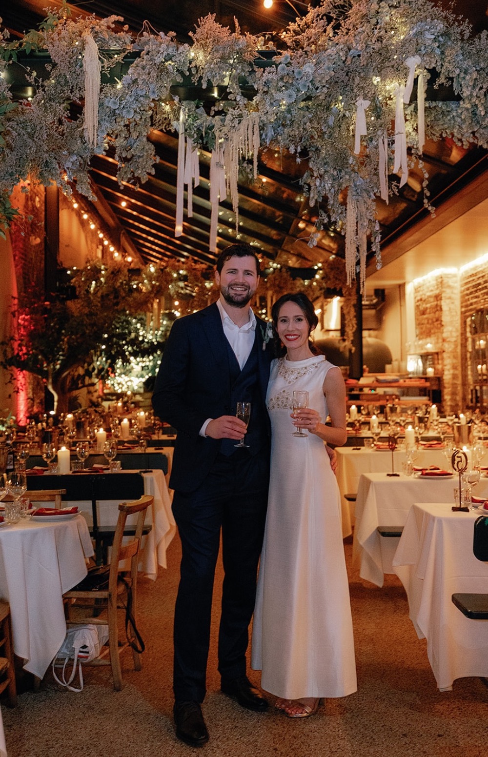Newly wedded guests standing under flowers